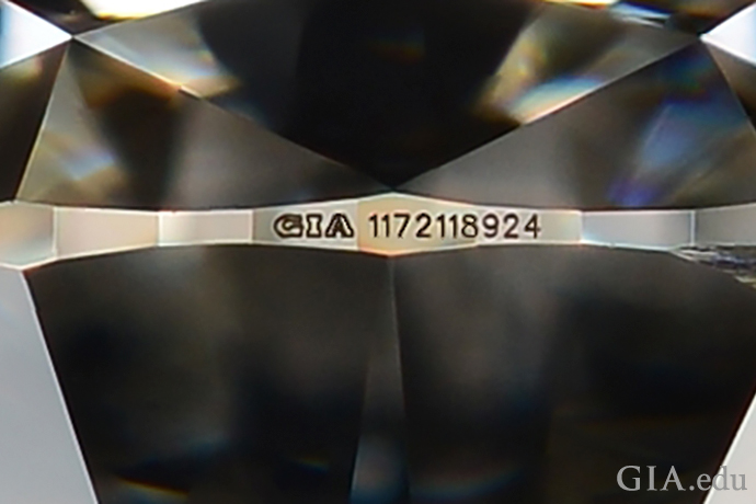 Forstørret eksempel på et GIA-rapportnummer laserinnskrevet på en diamant